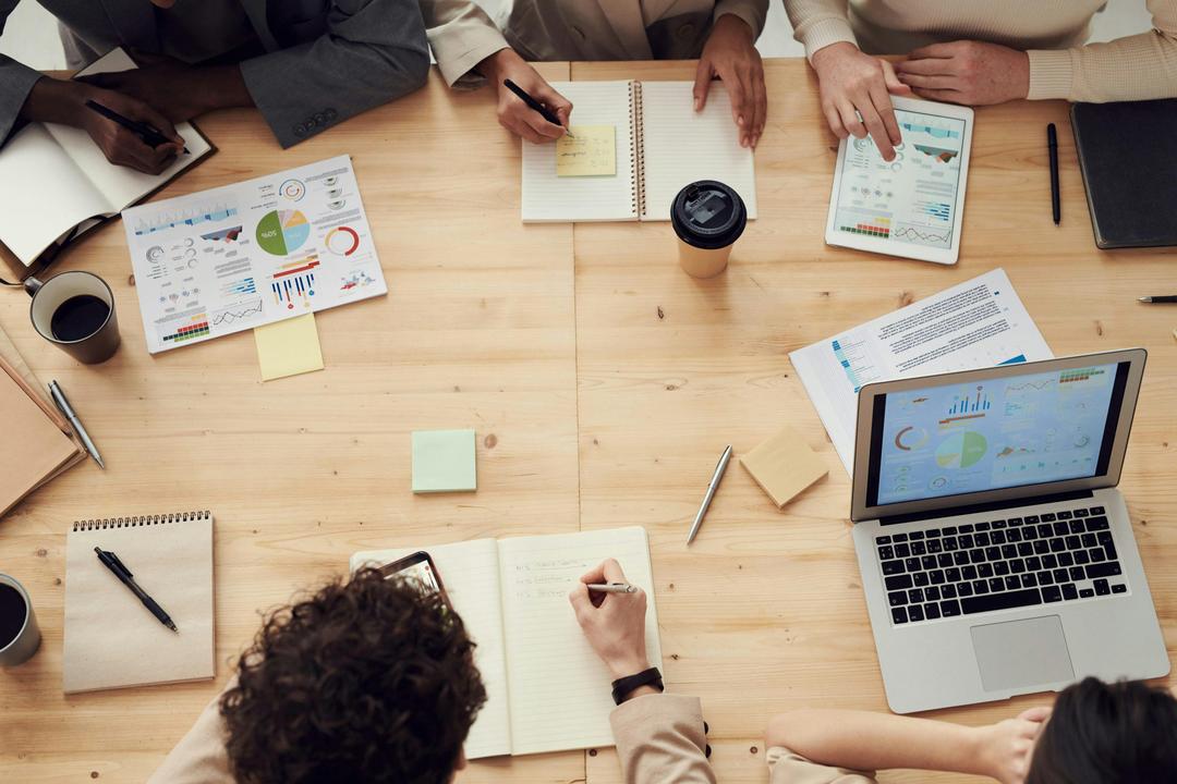 Group of people working at a table on computers