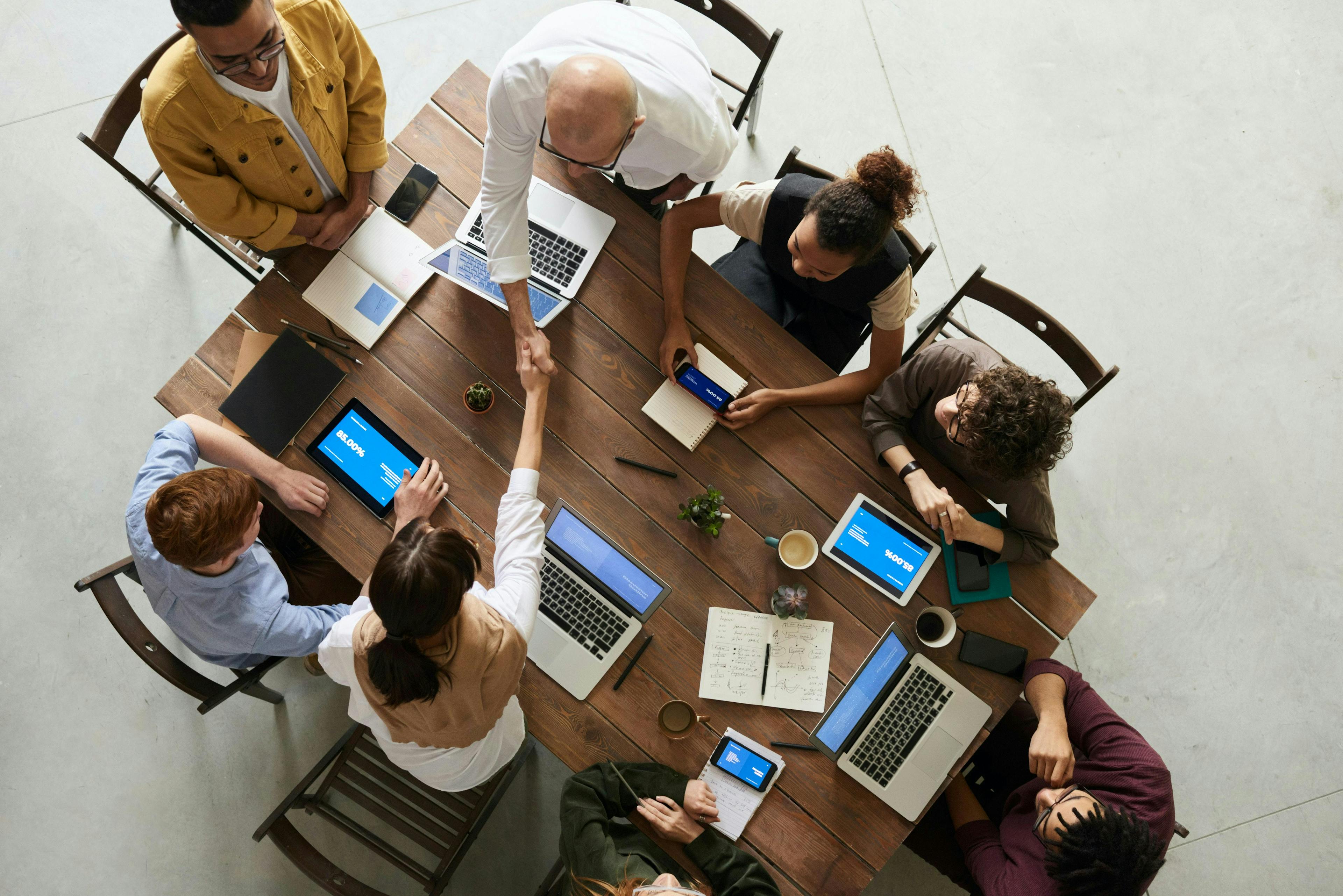 colleagues working on a table with laptops and pens