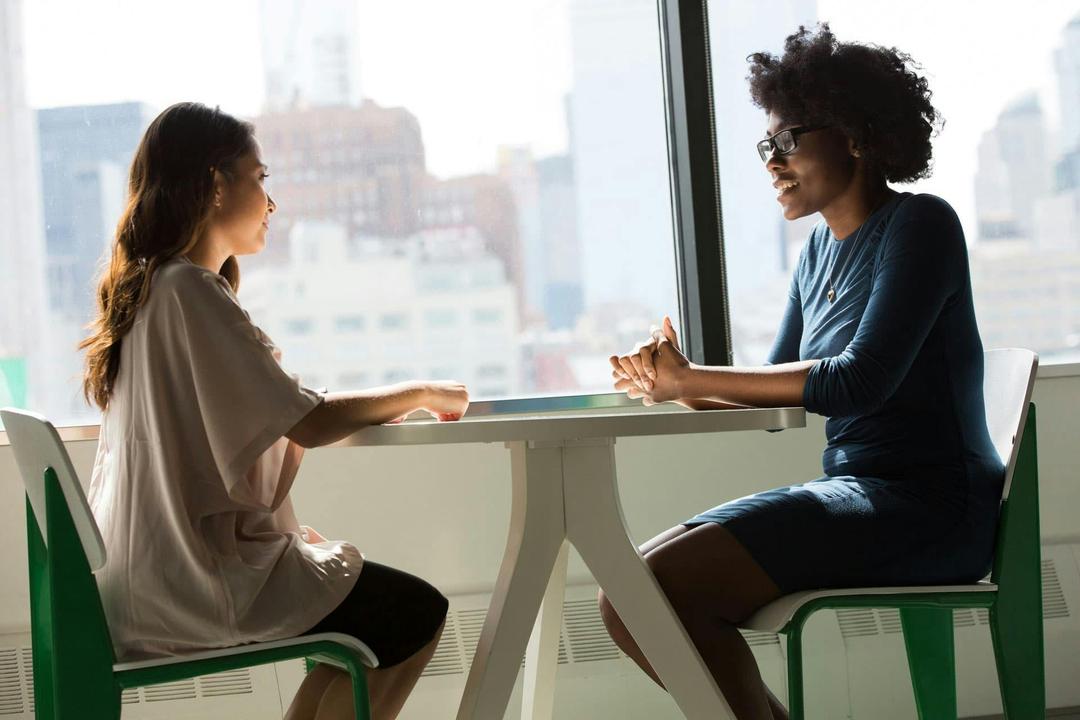 two women sitting and talking