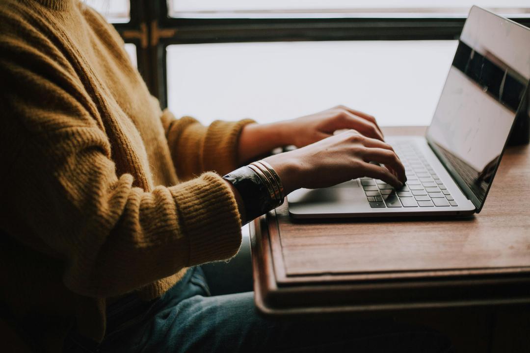 Man typing in front of a laptop