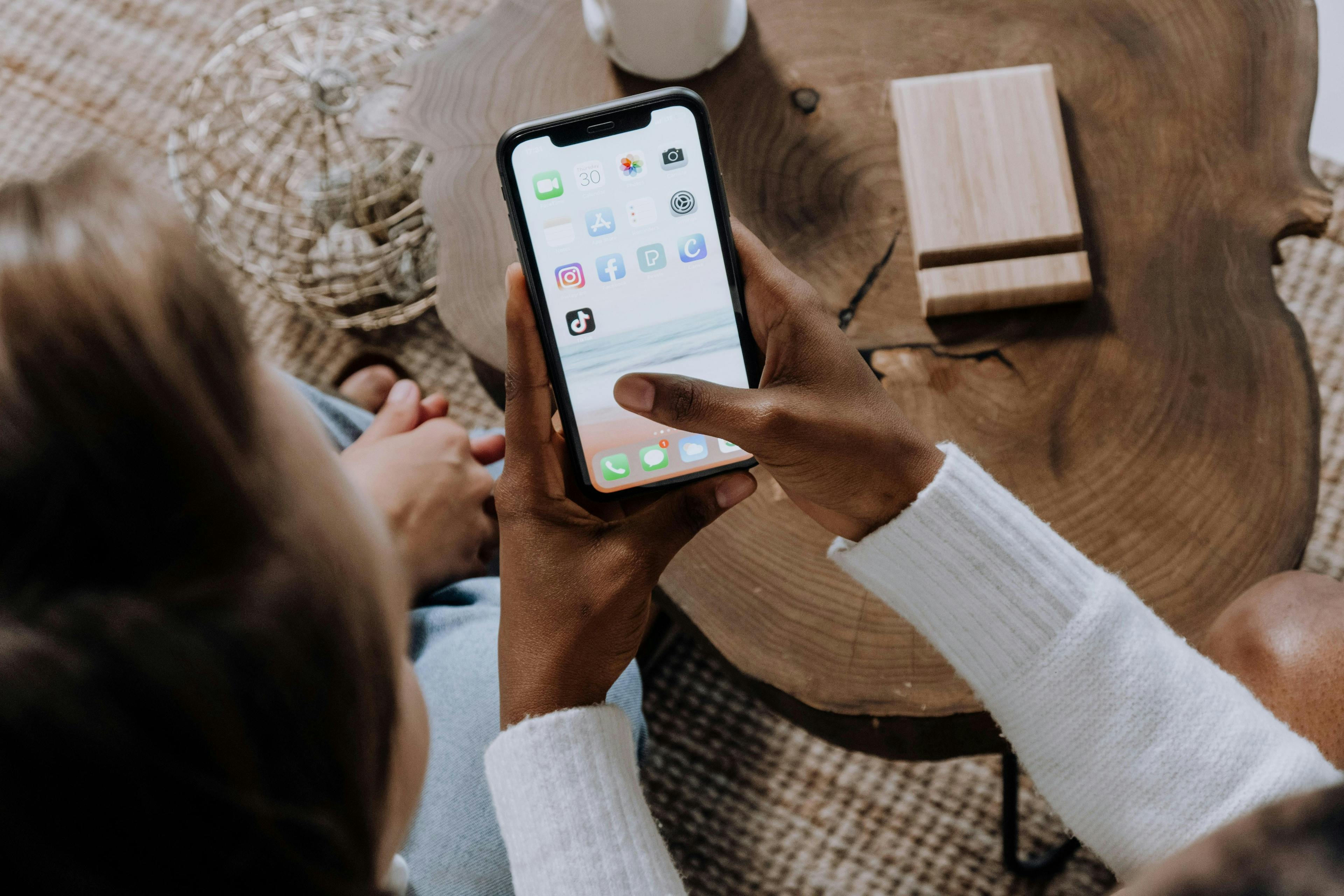 woman holding an iPhone with different apps