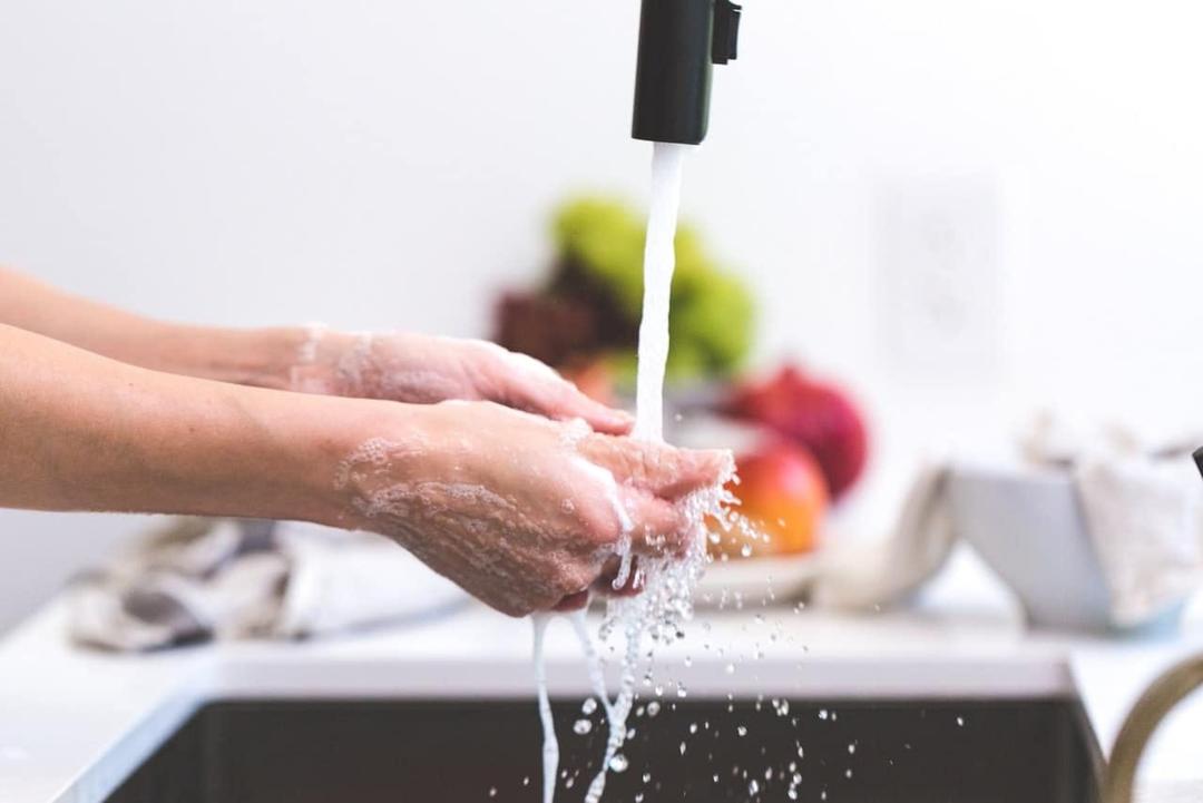 Woman washing hands in a sink