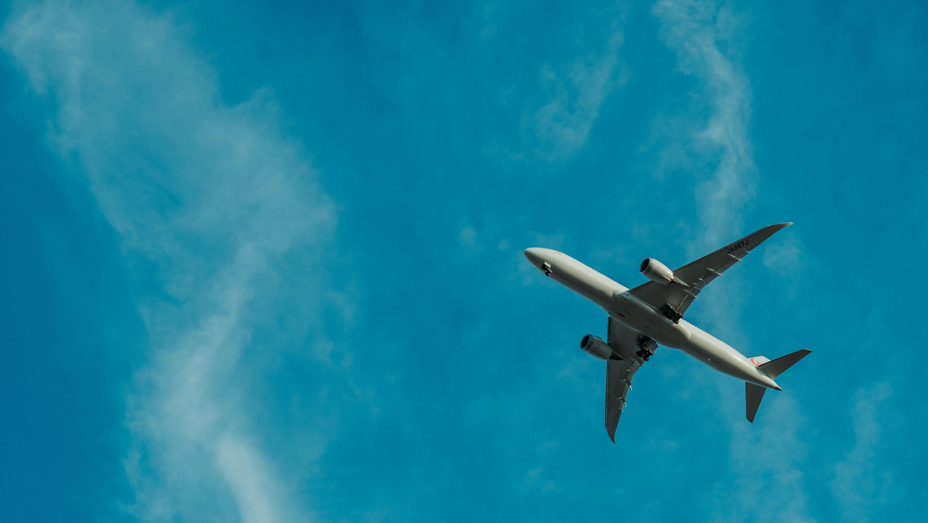 a picture of a plane seen from the ground with the background of a blue sky