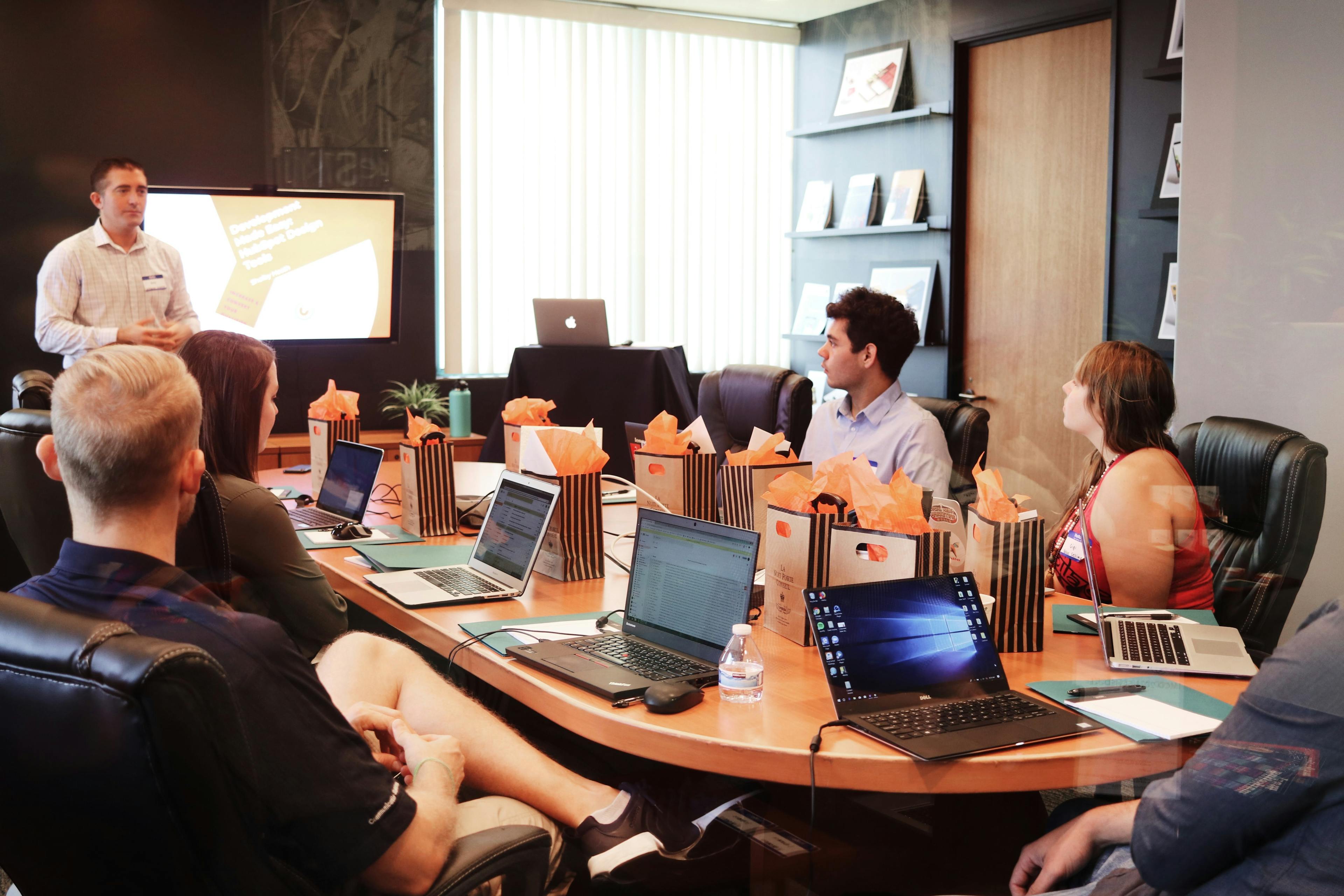 People in a meeting room with a man presenting.