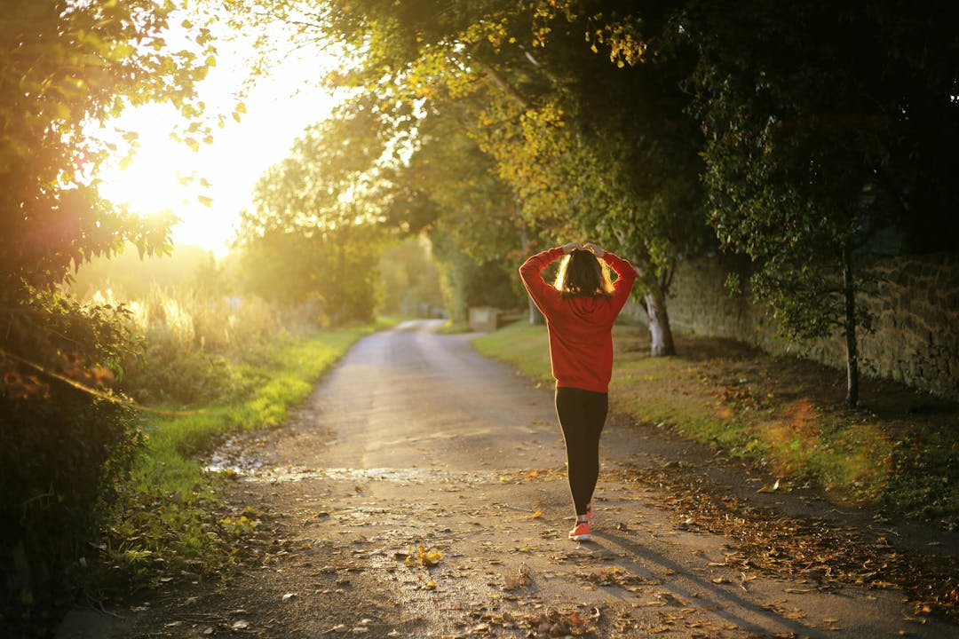 girl wearing a red hoodie walking on the street